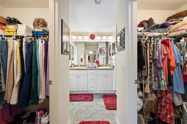 spacious closet with tile patterned flooring and a sink