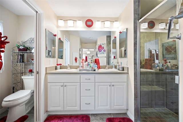 full bath featuring double vanity, a shower stall, toilet, and a sink