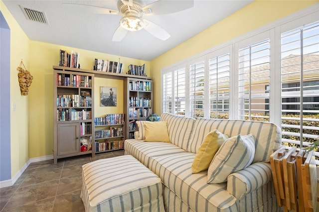 sitting room with visible vents, baseboards, and a ceiling fan