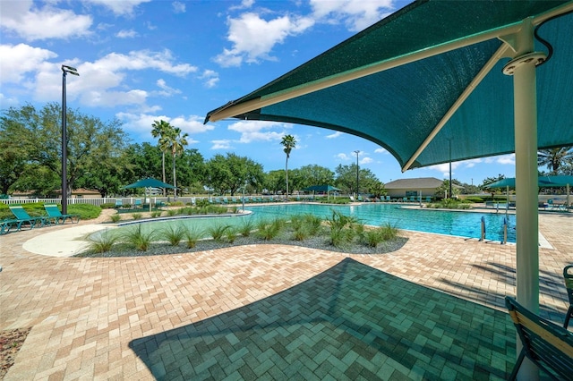 pool with a patio and fence