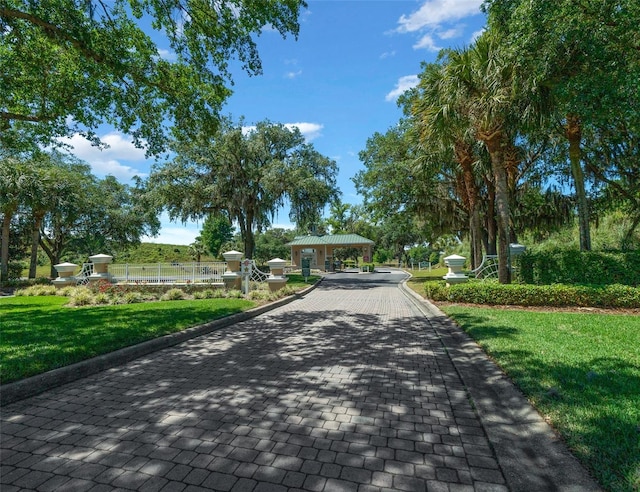 surrounding community featuring a gazebo, decorative driveway, and a lawn