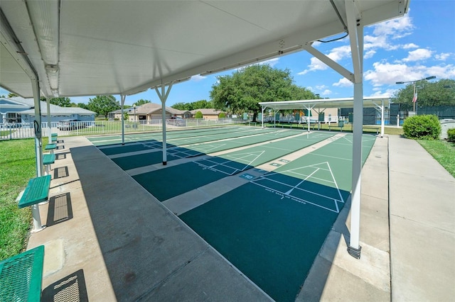 view of property's community with shuffleboard and fence