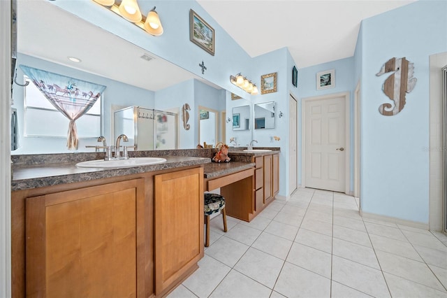 bathroom featuring a sink, double vanity, a shower stall, and tile patterned flooring