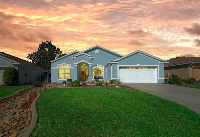 view of front facade featuring stucco siding, driveway, an attached garage, and a front lawn