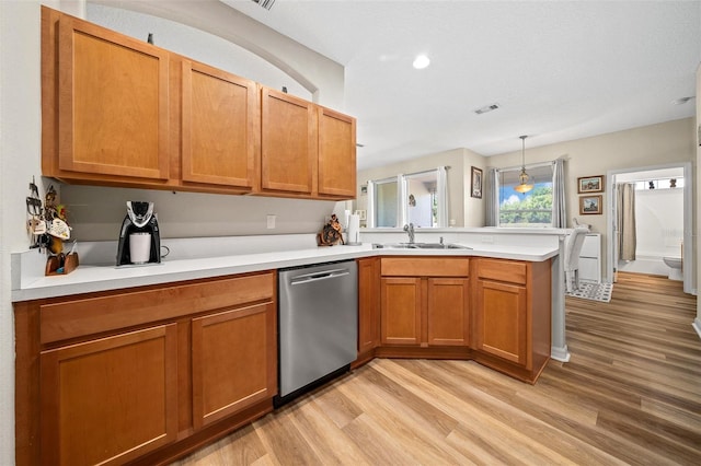 kitchen with a peninsula, light wood-style flooring, a sink, light countertops, and stainless steel dishwasher