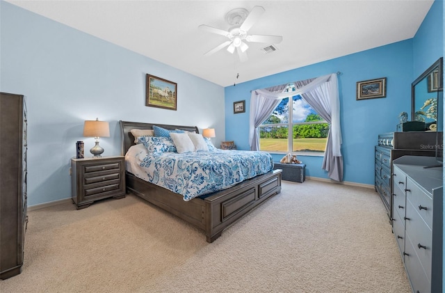 bedroom featuring ceiling fan, light colored carpet, visible vents, and baseboards