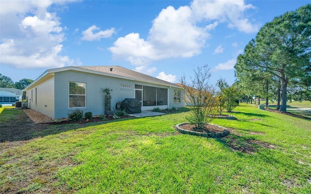 back of house featuring a yard, stucco siding, central AC, and a sunroom