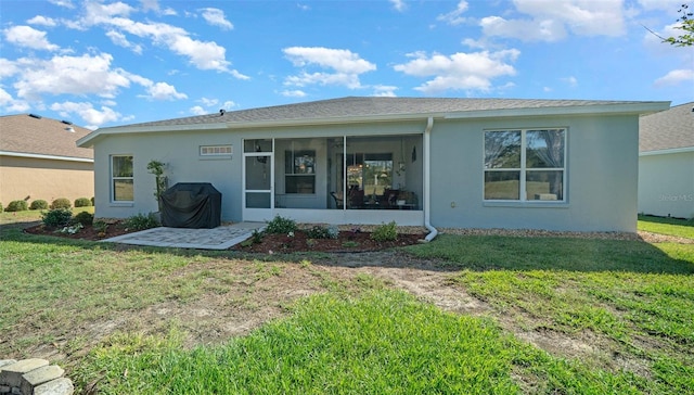 back of house with stucco siding, a lawn, and a sunroom