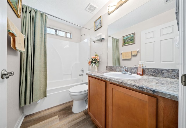 bathroom with visible vents, toilet, wood finished floors, shower / bath combination with curtain, and vanity