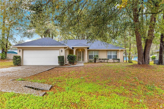 single story home with concrete driveway, a garage, and stucco siding