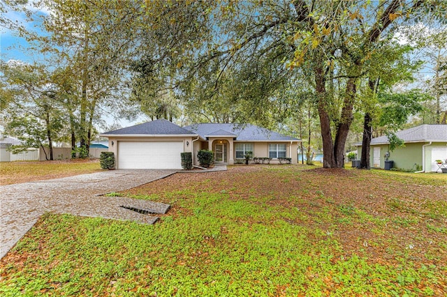 single story home with stucco siding, a front lawn, concrete driveway, and an attached garage