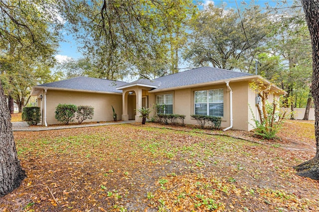 ranch-style house with stucco siding and roof with shingles