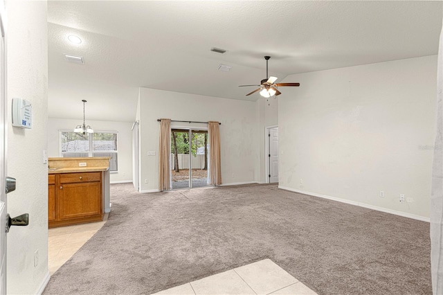 unfurnished living room with visible vents, light colored carpet, lofted ceiling, ceiling fan with notable chandelier, and a textured ceiling