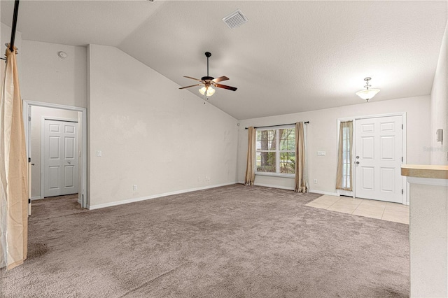 unfurnished living room with visible vents, high vaulted ceiling, a ceiling fan, baseboards, and light colored carpet