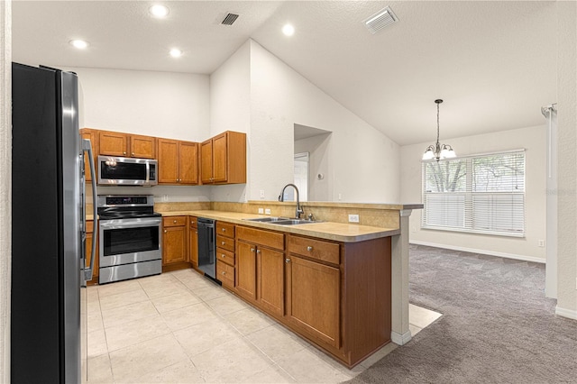 kitchen with brown cabinetry, visible vents, a peninsula, a sink, and appliances with stainless steel finishes