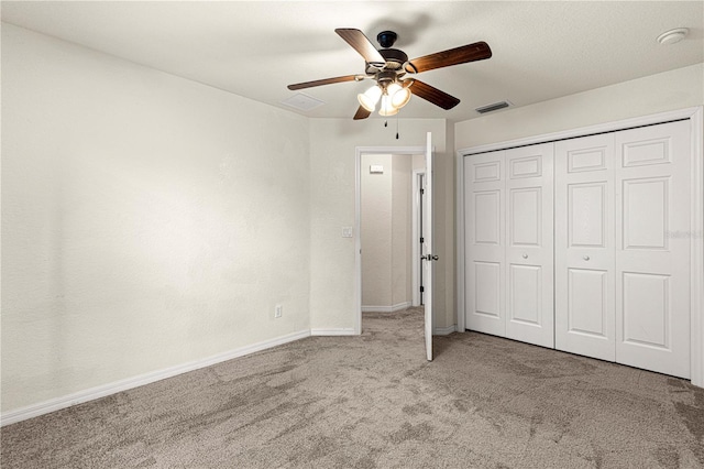 unfurnished bedroom with baseboards, visible vents, carpet floors, ceiling fan, and a closet