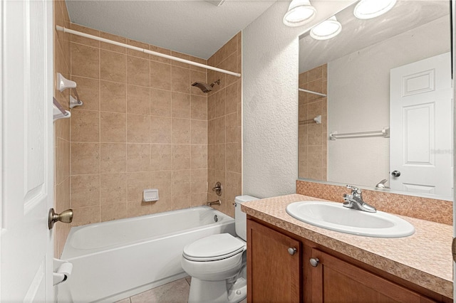 bathroom featuring tile patterned floors, toilet, tub / shower combination, vanity, and a textured wall