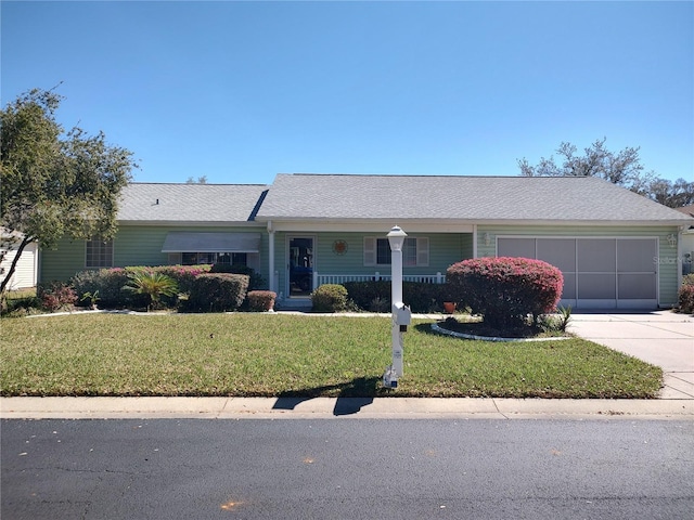 single story home featuring driveway, an attached garage, a porch, and a front yard