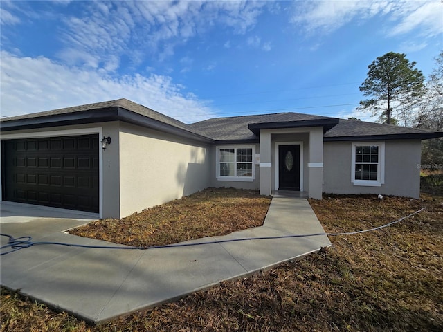 view of front of property featuring stucco siding, roof with shingles, and an attached garage