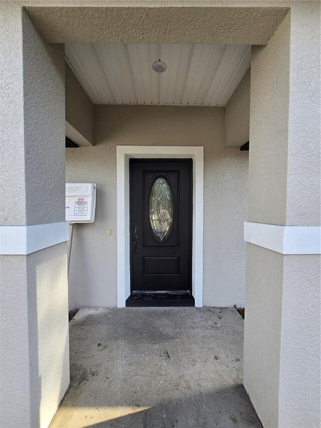 view of exterior entry featuring stucco siding