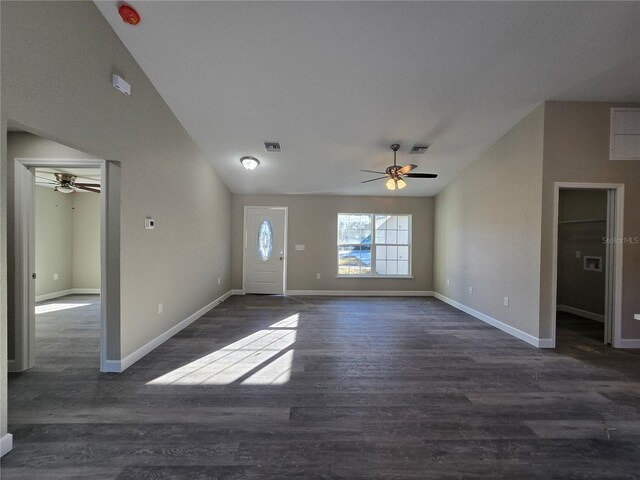 interior space featuring visible vents, wood finished floors, baseboards, and vaulted ceiling