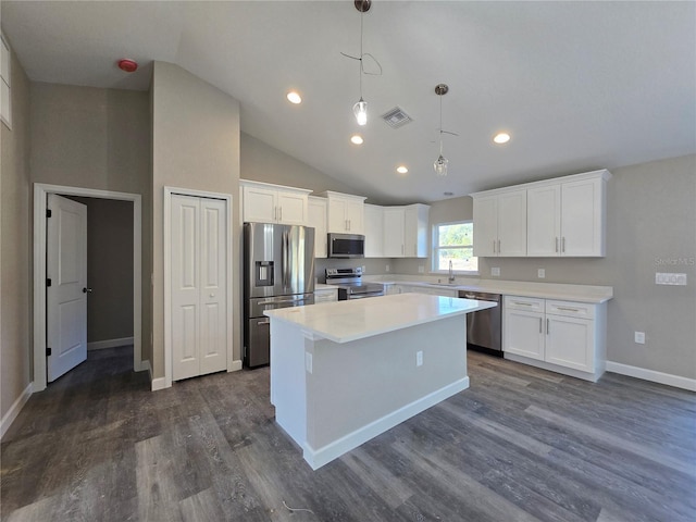 kitchen featuring visible vents, a sink, stainless steel appliances, white cabinets, and a center island