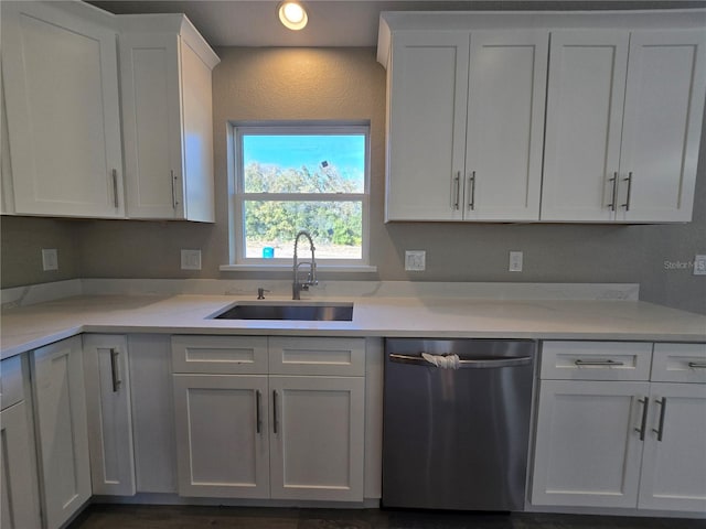 kitchen with stainless steel dishwasher, white cabinets, recessed lighting, and a sink