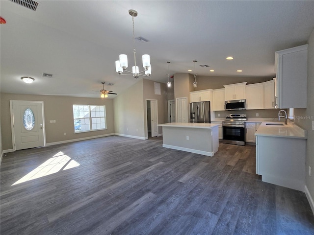 kitchen with a sink, open floor plan, a center island, appliances with stainless steel finishes, and light countertops