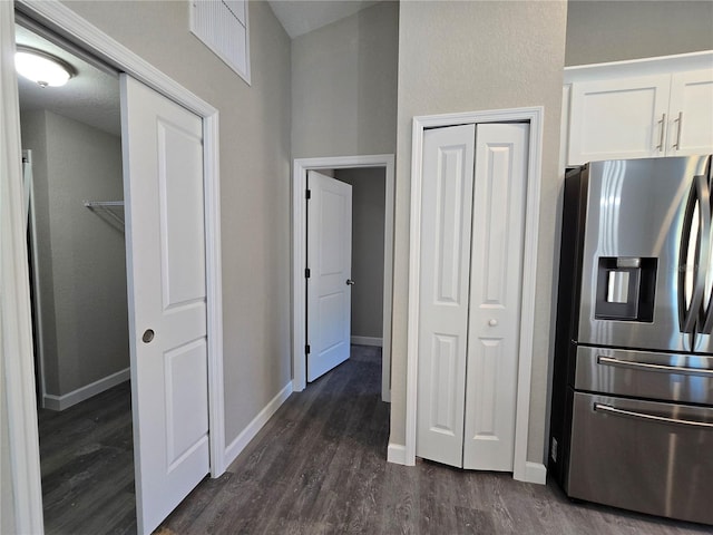 kitchen featuring stainless steel fridge, white cabinets, baseboards, and dark wood-style flooring