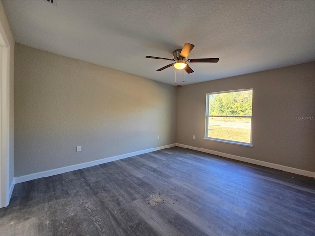 unfurnished room featuring dark wood finished floors, ceiling fan, baseboards, and a textured ceiling