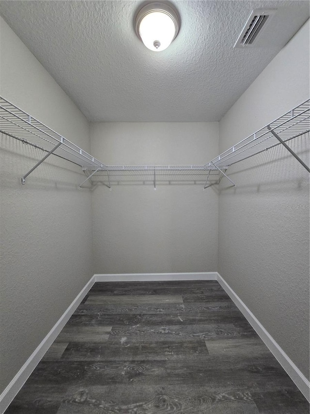 walk in closet featuring visible vents and dark wood-type flooring