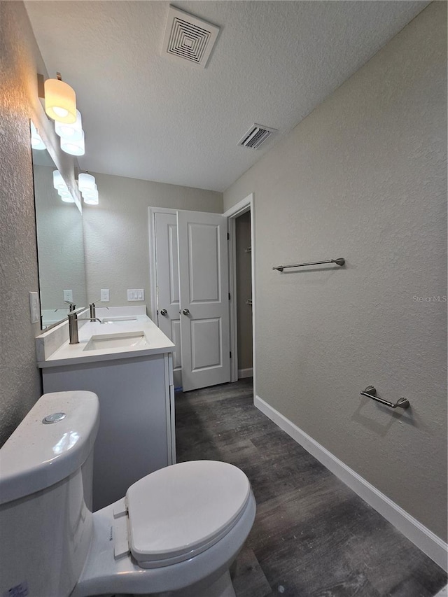 bathroom featuring visible vents, toilet, and a textured ceiling