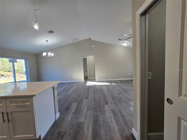 kitchen featuring vaulted ceiling, light countertops, visible vents, and dark wood-style flooring