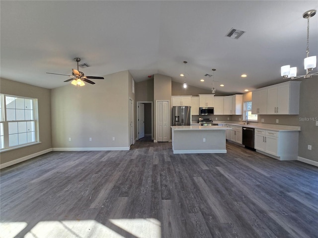 kitchen featuring visible vents, a kitchen island, open floor plan, stainless steel appliances, and light countertops