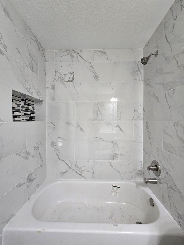 full bath featuring a textured ceiling and shower / bathing tub combination