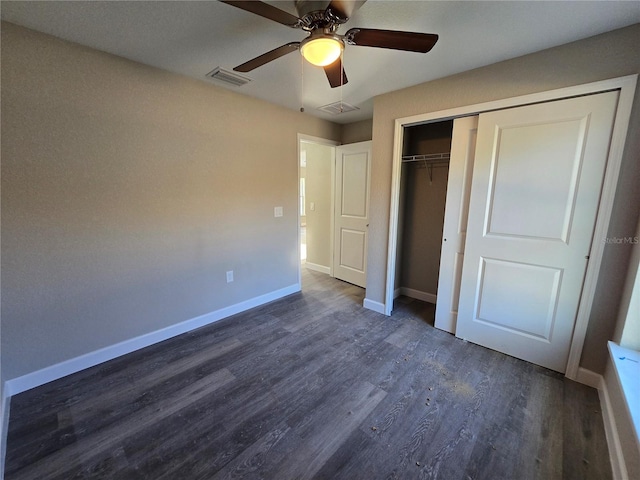 unfurnished bedroom with a closet, baseboards, visible vents, and dark wood-style flooring