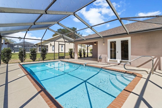 pool featuring glass enclosure, a patio, and french doors