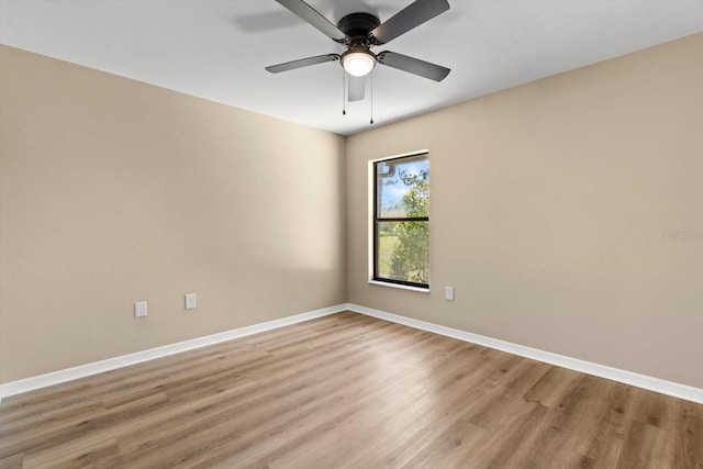 empty room featuring light wood finished floors, ceiling fan, and baseboards