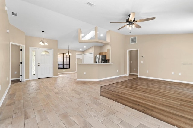 unfurnished living room featuring visible vents, ceiling fan with notable chandelier, and light wood finished floors