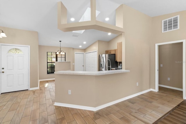 kitchen featuring light wood finished floors, visible vents, baseboards, stainless steel fridge with ice dispenser, and an inviting chandelier