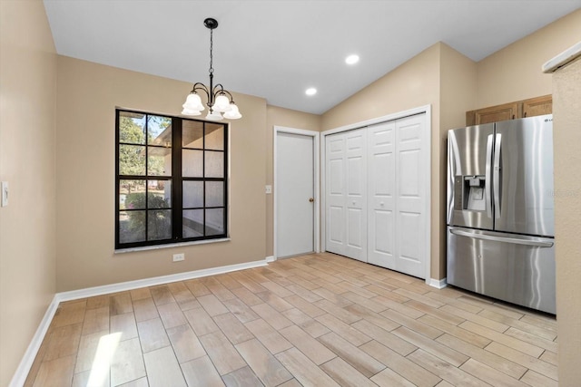 kitchen with light wood-style flooring, stainless steel refrigerator with ice dispenser, recessed lighting, baseboards, and hanging light fixtures