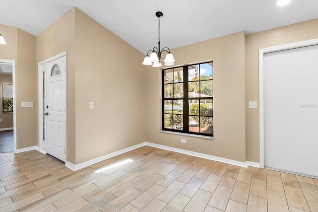 unfurnished dining area featuring lofted ceiling, a notable chandelier, baseboards, and light wood finished floors