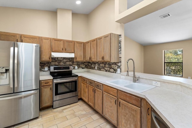 kitchen with visible vents, under cabinet range hood, light countertops, appliances with stainless steel finishes, and a sink