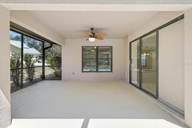 unfurnished sunroom featuring ceiling fan