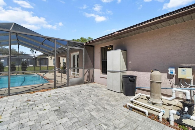 view of patio / terrace featuring glass enclosure and an outdoor pool