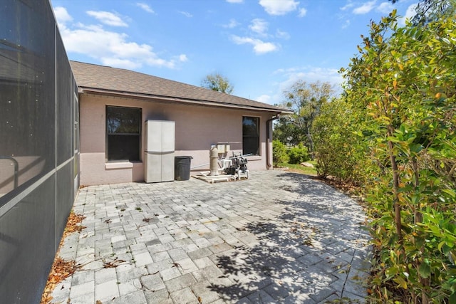 view of patio featuring glass enclosure