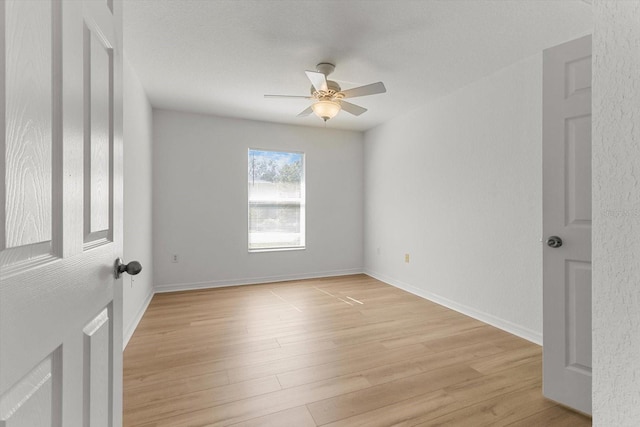 empty room featuring baseboards, light wood-style floors, and ceiling fan