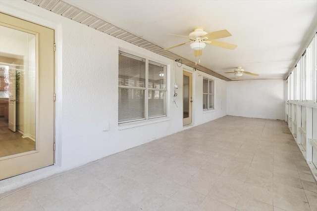 unfurnished sunroom with ceiling fan