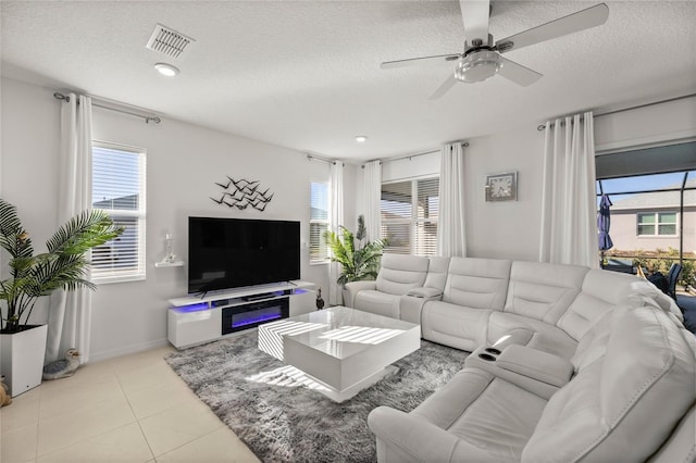 living room with tile patterned flooring, visible vents, and a textured ceiling