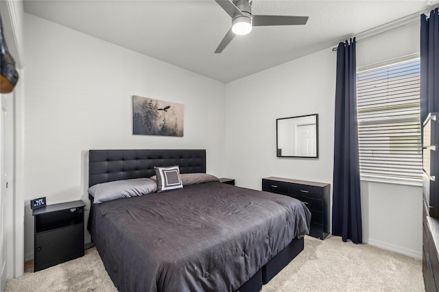 bedroom with light carpet, baseboards, and a ceiling fan